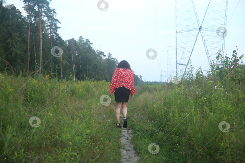 Скачать красивая девушка гуляет в поле среди растений фотосток Ozero