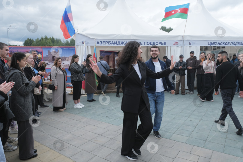Скачать Пара танцует лезгинку возле павильона Азербайджана на фестивале "День народов Среднего Урала" фотосток Ozero