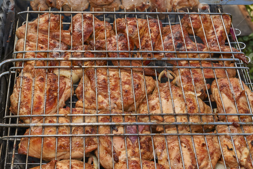 Скачать Кусочки курицы с золотистой корочкой обжариваются на гриле над углями. фотосток Ozero