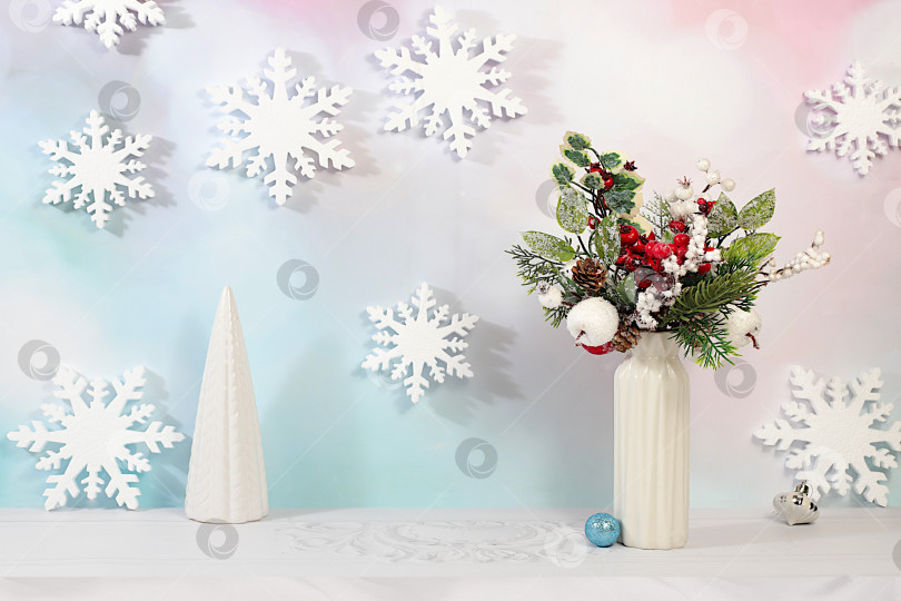Скачать Концепция кануна Рождества. Рождественский и новогодний макет для оформления и демонстрации продукции со снежинками и креативным рождественским букетом из свежих еловых веток и украшений на элегантном праздничном фоне. фотосток Ozero