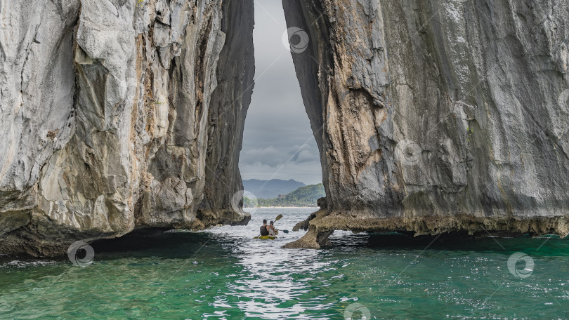 Скачать Высокие скалы в океане. Между крутыми склонами есть арочный проем. фотосток Ozero