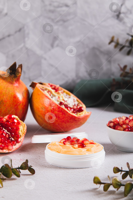 Скачать Гранатовый крем для ухода за кожей в баночке и фрукты на столе, вид сверху фотосток Ozero