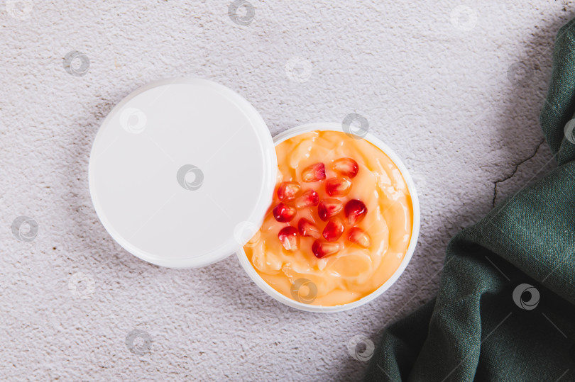 Скачать Крупным планом гранатовый крем для ухода за кожей в банке и зернышки на столе вид сверху фотосток Ozero