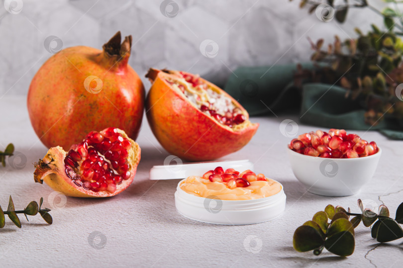 Скачать Гранатовый крем для ухода за кожей в баночке и фрукты на столе фотосток Ozero