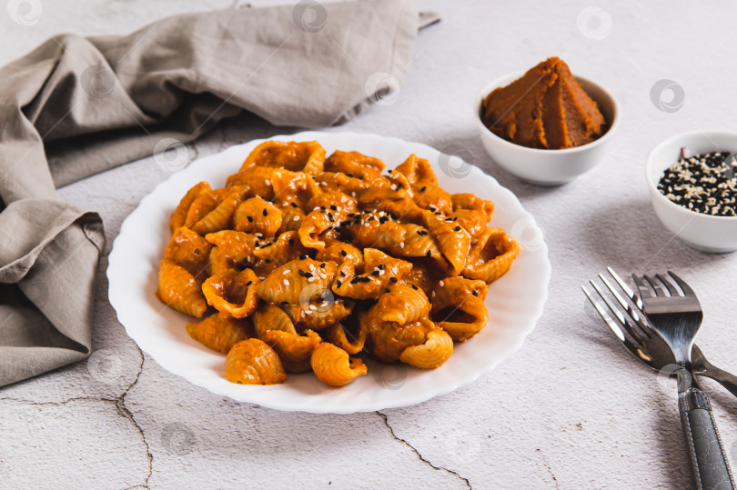 Скачать Вкуснейшая паста из ракушек с пастой мисо на тарелке на столе фотосток Ozero