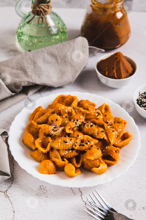 Скачать Вкусная паста из ракушек с пастой мисо на тарелке на столе, вид сверху фотосток Ozero