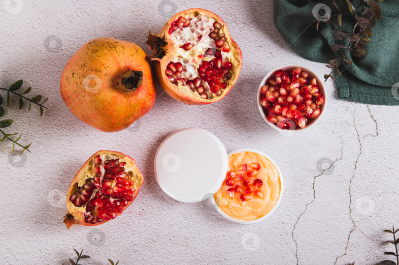 Скачать Гранатовый крем для ухода за кожей в баночке и фрукты на столе вид сверху фотосток Ozero