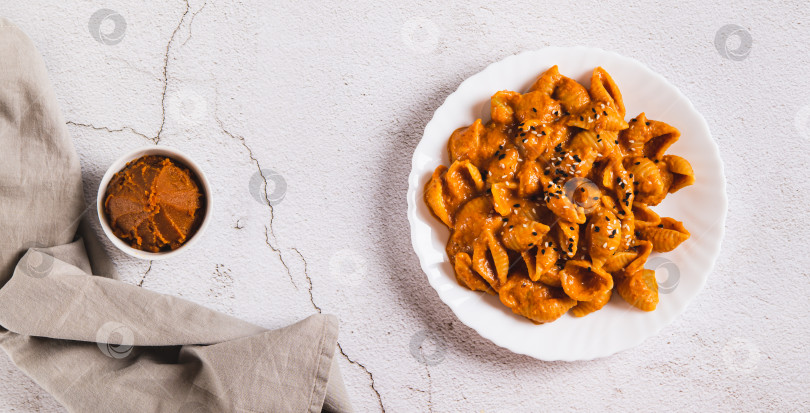 Скачать Вкусная паста из ракушек с пастой мисо на тарелке на столешнице посмотреть веб-баннер фотосток Ozero