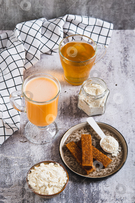 Скачать Белковое питание и зеленый чай для ухода за микробиомом кожи, разложенные на столе в вертикальном положении фотосток Ozero