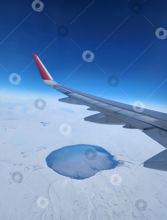 Скачать Крыло самолета, летящего над землей и озером. Вид с высоты птичьего полета. фотосток Ozero