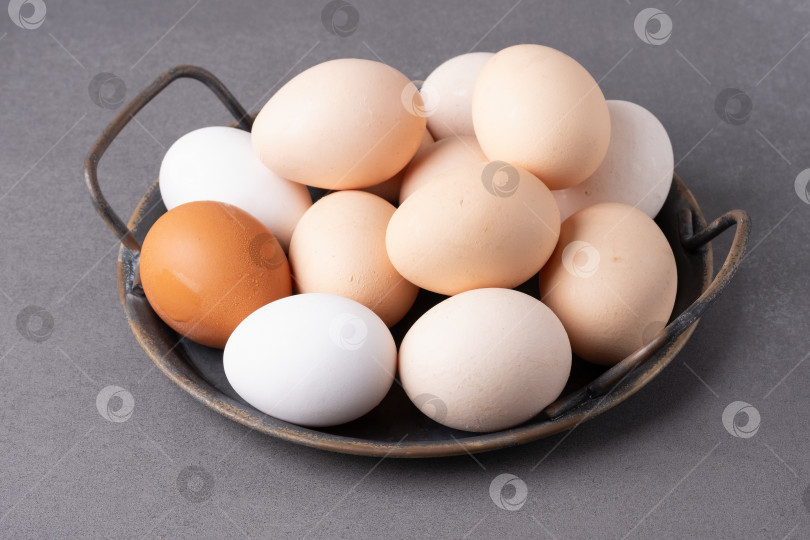 Скачать Коллекция свежих яиц в деревенской миске на серой поверхности фотосток Ozero