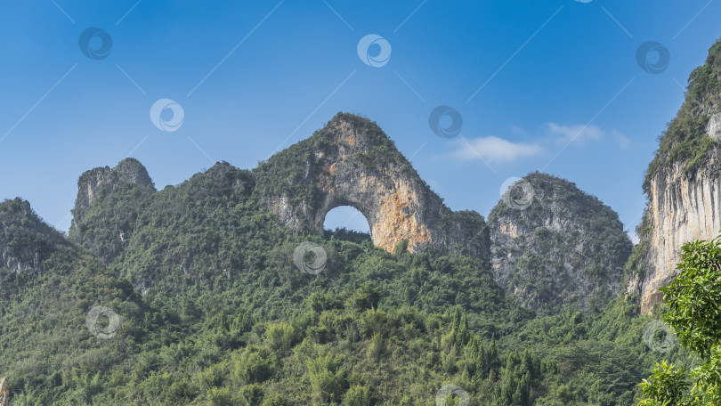 Скачать Красивый горный пейзаж. Необычная скала с округлым арочным отверстием на вершине. фотосток Ozero