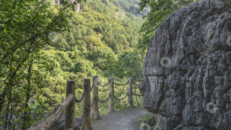 Скачать Вокруг скалы проходит пешеходная дорожка. Перила сделаны из бревен и цепей. фотосток Ozero