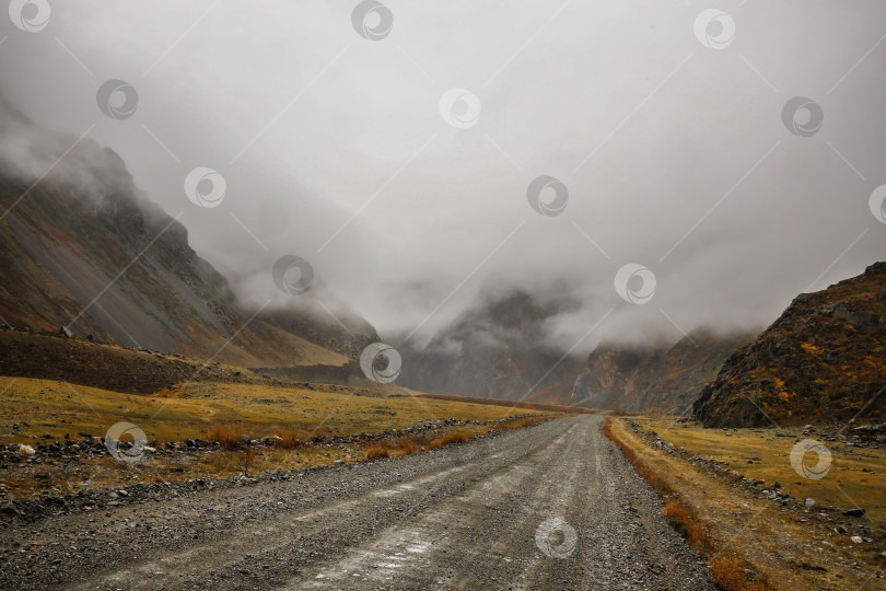 Скачать Бездорожье, мокрая извилистая грунтовая дорога вверх по склону фотосток Ozero