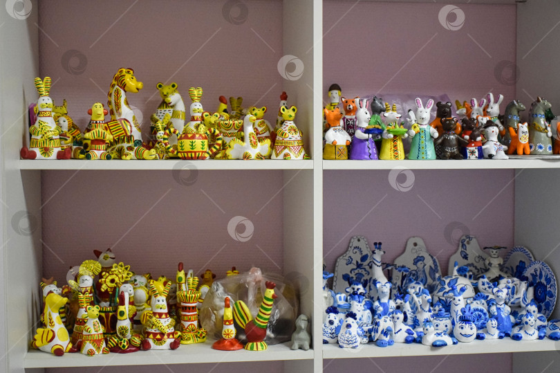Скачать Выставочные полки с детскими поделками из глины в стилях: Гжель, Филимоновская игрушка, Дымковская игрушка фотосток Ozero