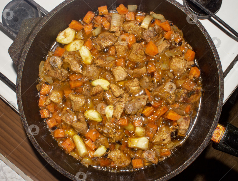 Скачать Запеканка с мясом для плова.Начинка для плова.Запеченное мясо с морковью и луком.На фоне поджаренного мяса. фотосток Ozero