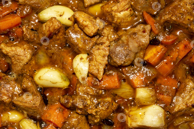 Скачать Запеканка с мясом для плова.Начинка для плова.Запеченное мясо с морковью и луком.На фоне поджаренного мяса. фотосток Ozero