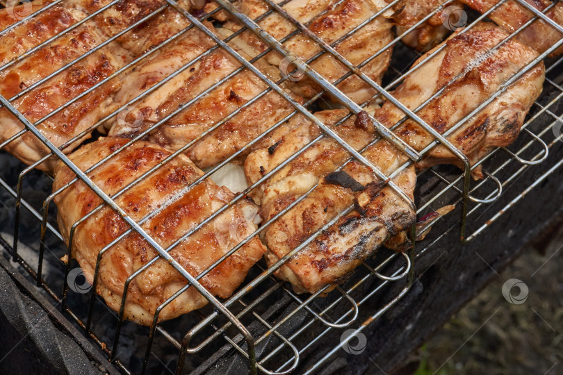 Скачать Кусочки курицы с золотистой корочкой обжариваются на гриле над углями. фотосток Ozero