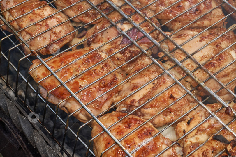 Скачать Кусочки курицы с золотистой корочкой обжариваются на гриле над углями. фотосток Ozero