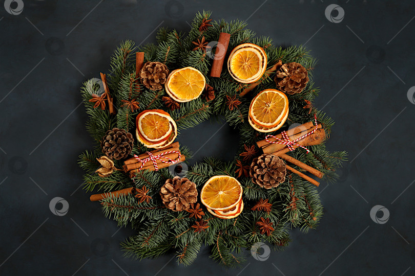 Скачать Рождественский венок из свежих еловых веток, корицы, апельсина, звездчатого аниса, сосновых шишек и украшений, шаблон дизайна, рождественская композиция и концепция Нового 2026 года, красивое праздничное оформление, зимний баннер, макет праздничной рекламы, фотосток Ozero
