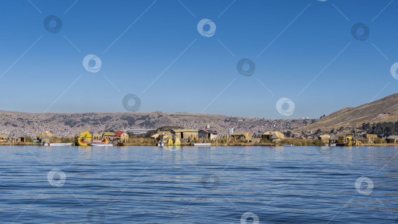 Скачать Высокогорное озеро Титикака. У берега пришвартованы моторные лодки и катера из Бальса-де-тотора. фотосток Ozero