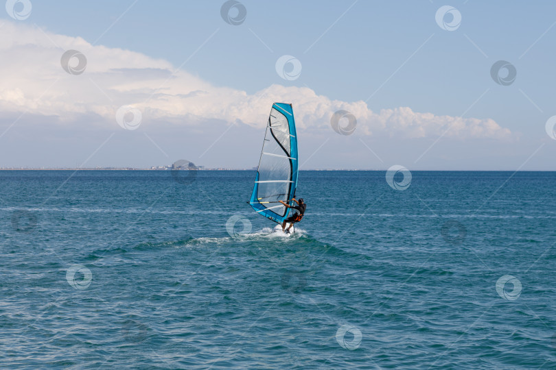 Скачать Евпатория, Россия - сентября 16, 2025- Мужчина, занимающийся виндсерфингом фотосток Ozero