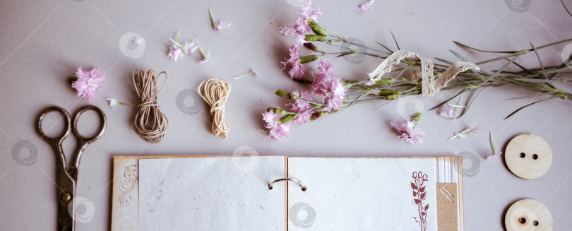 Скачать Винтажный фон, ручная работа. Старые ножницы, ленты, деревянные пуговицы, блокнот для текста и цветы. фотосток Ozero