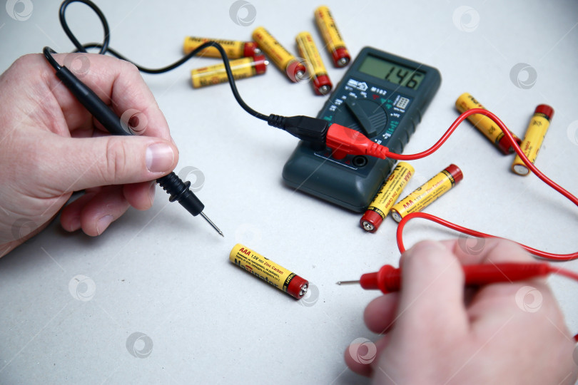 Скачать Краснодар, Россия - 18 ноября 2018 г. Проверка заряда аккумулятора с помощью мультиметра крупным планом. фотосток Ozero