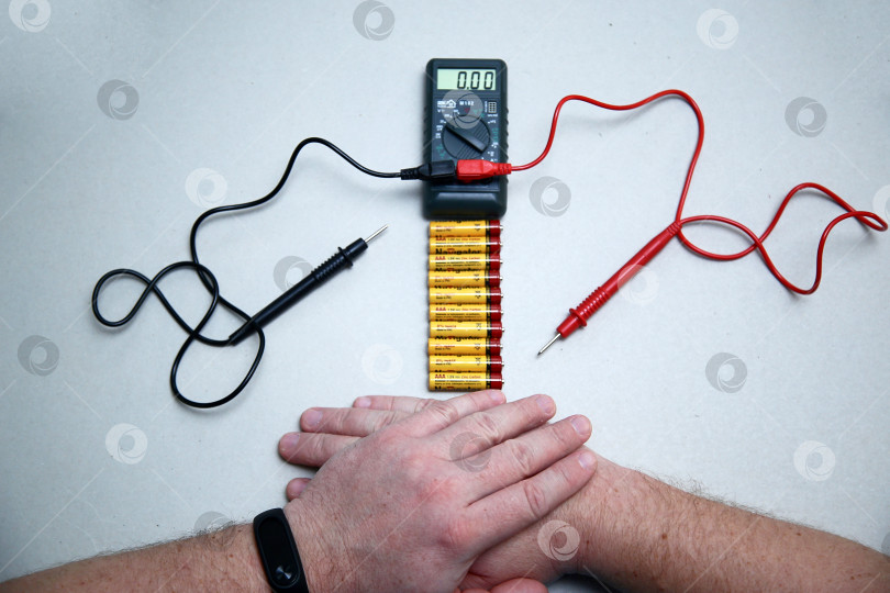 Скачать Краснодар, Россия - 18 ноября 2018 г. Проверка заряда аккумулятора с помощью мультиметра крупным планом. фотосток Ozero