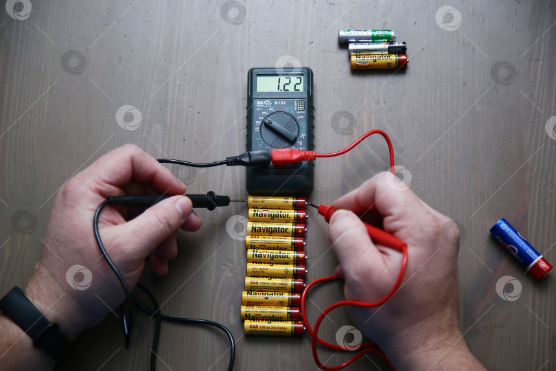 Скачать Краснодар, Россия - 18 ноября 2018 г. Проверка заряда аккумулятора с помощью мультиметра крупным планом. фотосток Ozero