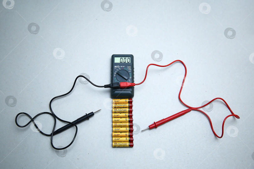 Скачать Краснодар, Россия - 18 ноября 2018 г. Проверка заряда аккумулятора с помощью мультиметра крупным планом. фотосток Ozero