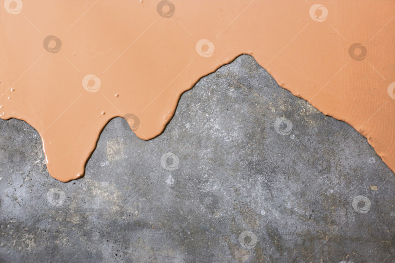 Скачать Бетонный пол окрашен в светло-оранжевый цвет. Подрядчик покрасит пол в гараже, чтобы ускорить продажу дома фотосток Ozero