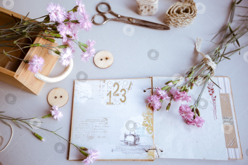 Скачать Винтажный фон, ручная работа. Старые ножницы, ленты, деревянные пуговицы, блокнот для текста и цветы. фотосток Ozero