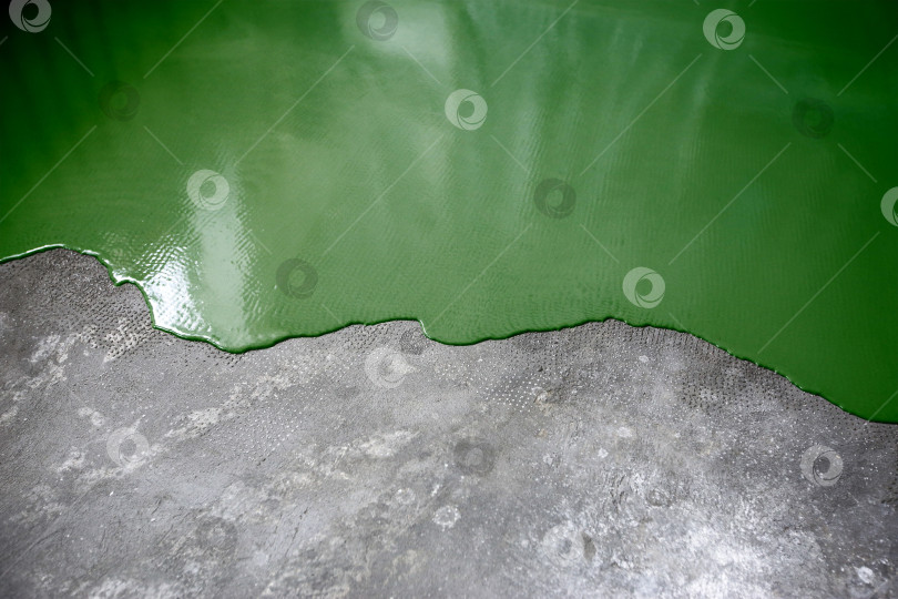 Скачать Бетонный пол окрашен в темно-зеленый цвет. Подрядчик покрасит пол в гараже, чтобы ускорить продажу дома фотосток Ozero