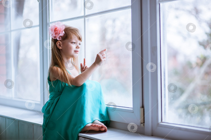 Скачать Красивая девушка рисует на оконном стекле пальцем фотосток Ozero