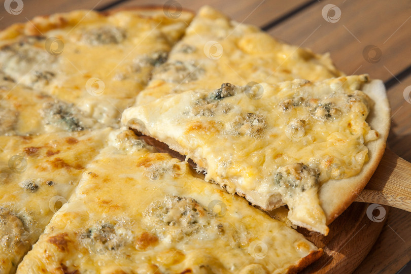 Скачать Сырная пицца на деревянной доске фотосток Ozero