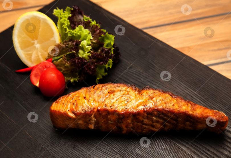 Скачать Стейк из лосося на гриле с овощами на деревянной доске. Европейская кухня. фотосток Ozero