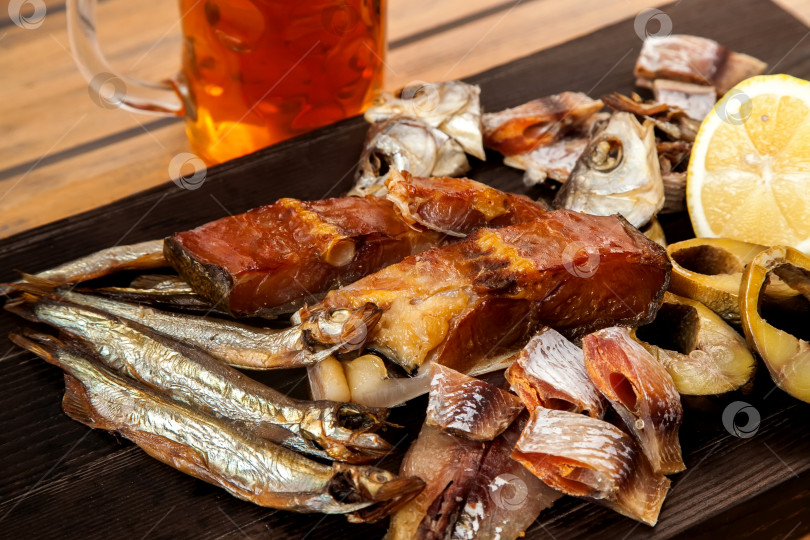 Скачать Вяленая рыба на деревянной доске. Горбуша, скумбрия, плотва и мойва. Закуска к пиву. фотосток Ozero