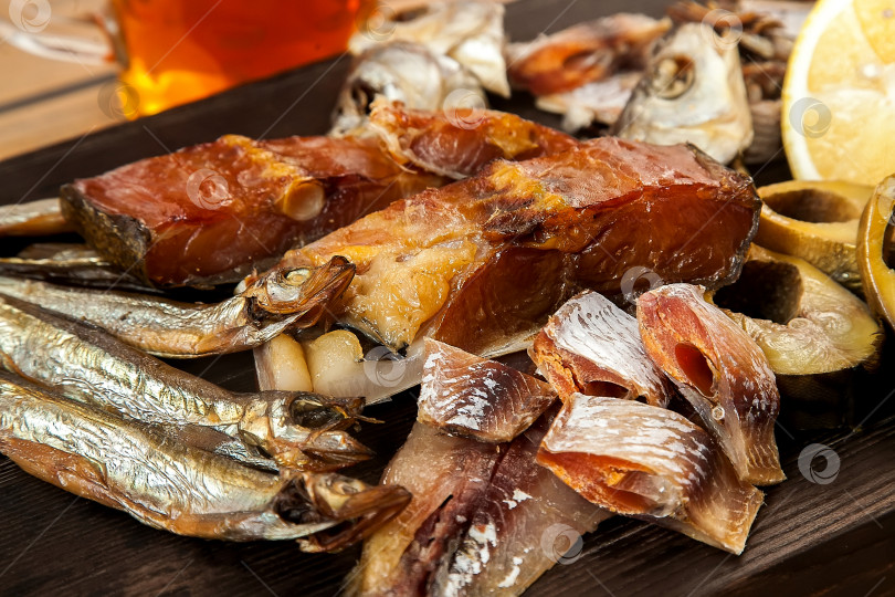 Скачать Вяленая рыба на деревянной доске. Горбуша, скумбрия, плотва и мойва. Закуска к пиву. фотосток Ozero