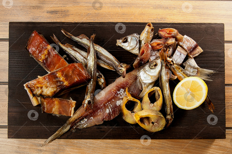 Скачать Вяленая рыба на деревянной доске. Горбуша, скумбрия, плотва и мойва. Закуска к пиву. фотосток Ozero