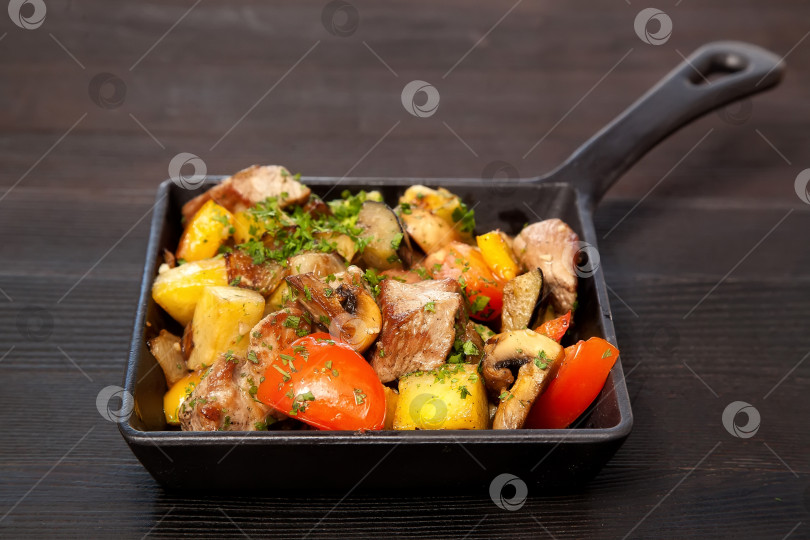 Скачать Мясо, грибы и овощи на сковороде фотосток Ozero