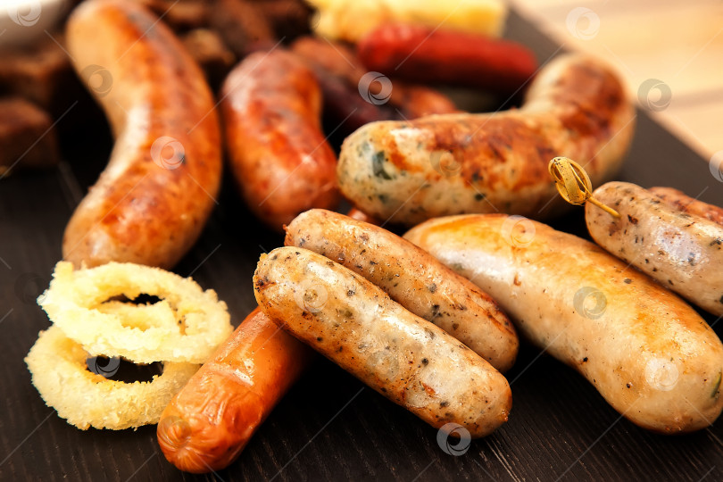 Скачать Сосиски и сардельки-гриль. Фастфуд - вредная жирная пища. Ассорти из пива, приготовленного на гриле фотосток Ozero
