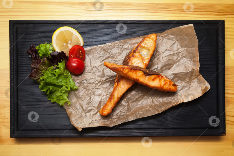 Скачать Стейк из форели на гриле с овощами на деревянной доске. Европейская кухня. фотосток Ozero