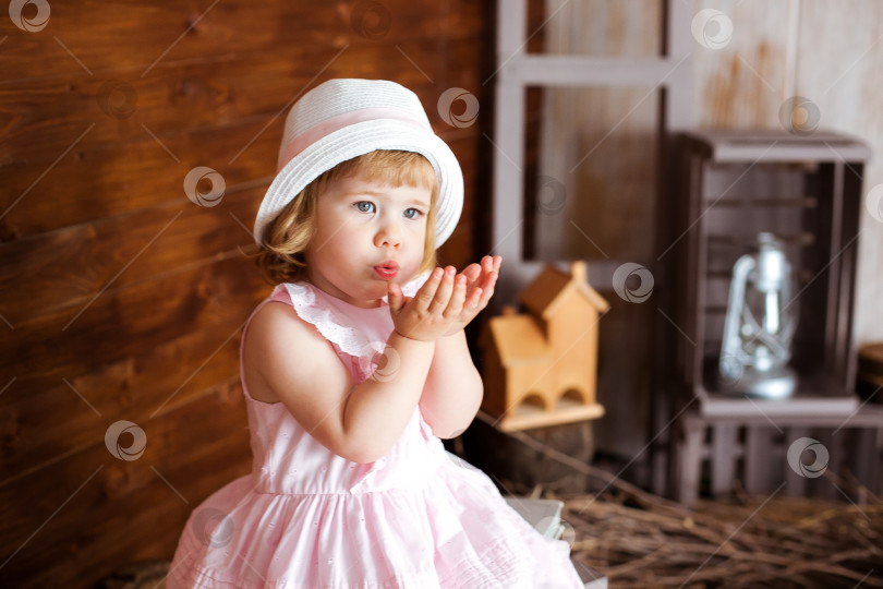 Скачать Маленькая девочка в розовой шапочке дует тебе на ладонь. фотосток Ozero