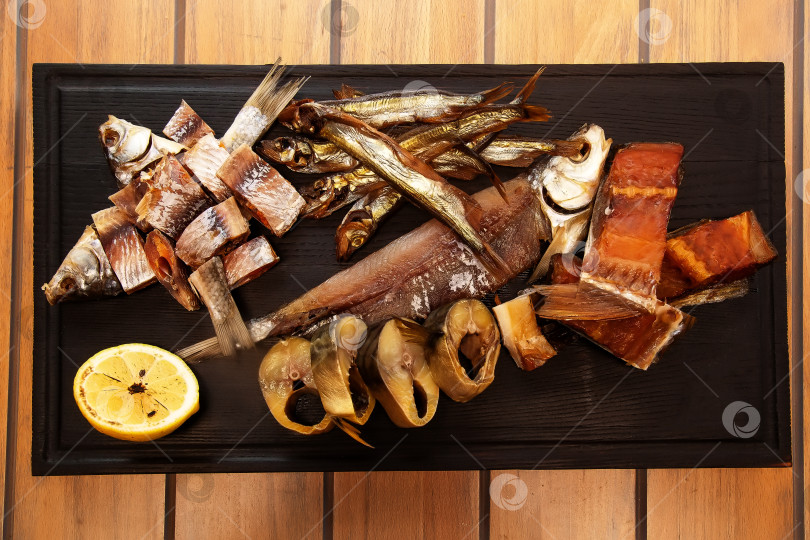 Скачать Вяленая рыба на деревянной доске. Горбуша, скумбрия, плотва и мойва. Закуска к пиву. фотосток Ozero