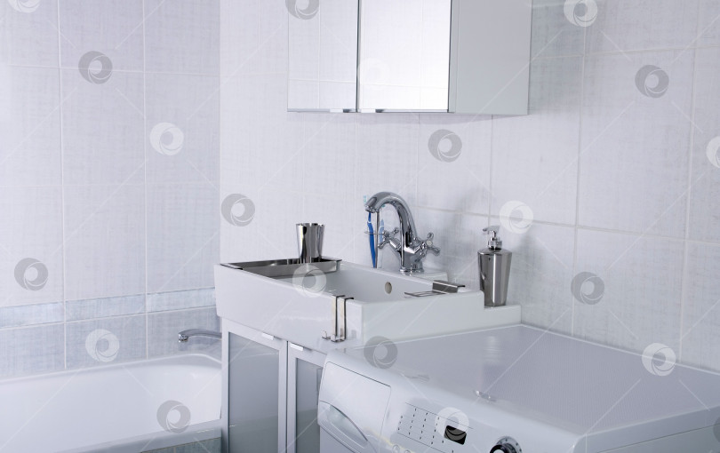 Скачать Новая сантехника. Хромированный смеситель и белая раковина в ванной комнате. фотосток Ozero