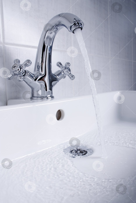 Скачать Новая сантехника. Хромированный смеситель и белая раковина в ванной комнате. фотосток Ozero