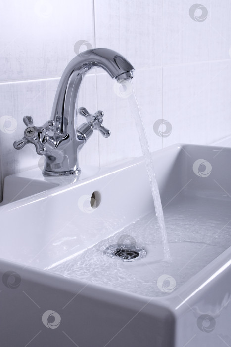 Скачать Новая сантехника. Хромированный смеситель и белая раковина в ванной комнате. фотосток Ozero