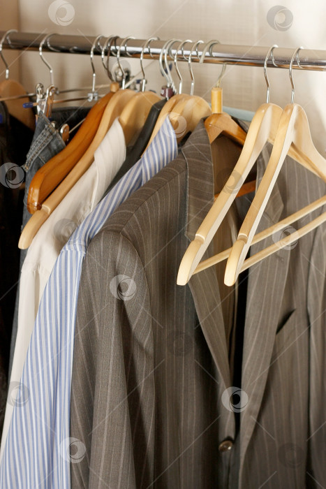 Скачать Деревянные вешалки в шкафу с мужской одеждой. Шкаф-купе в доме. фотосток Ozero