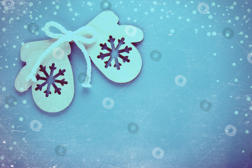 Скачать Деревянная игрушечная варежка на праздничном фоне. Винтажная тонировка и царапины. фотосток Ozero